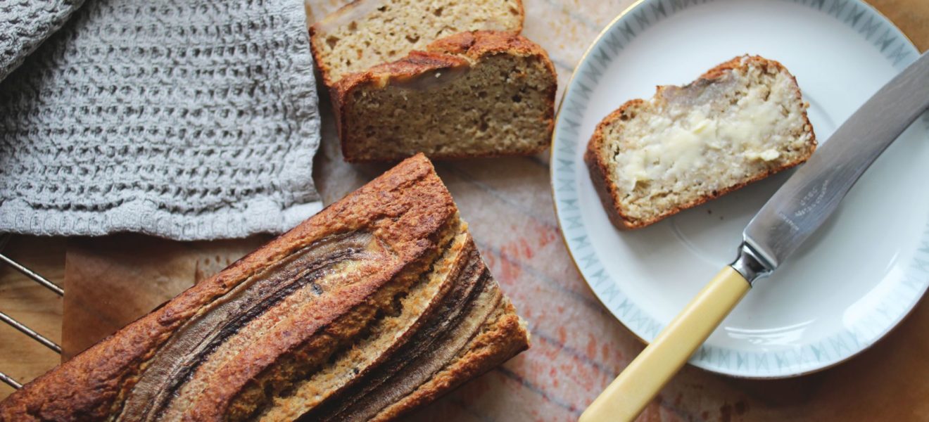 nystekt bananbrød på fjøl, kniv og smør