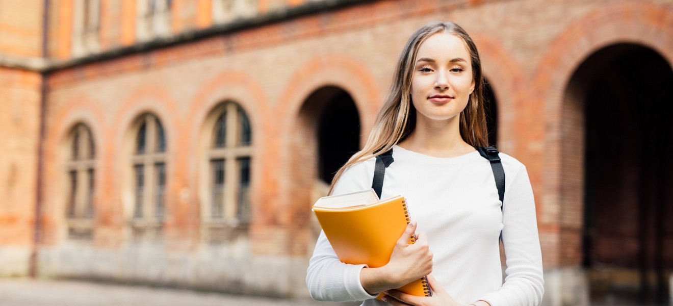 jente student utenfor skole med notatbok