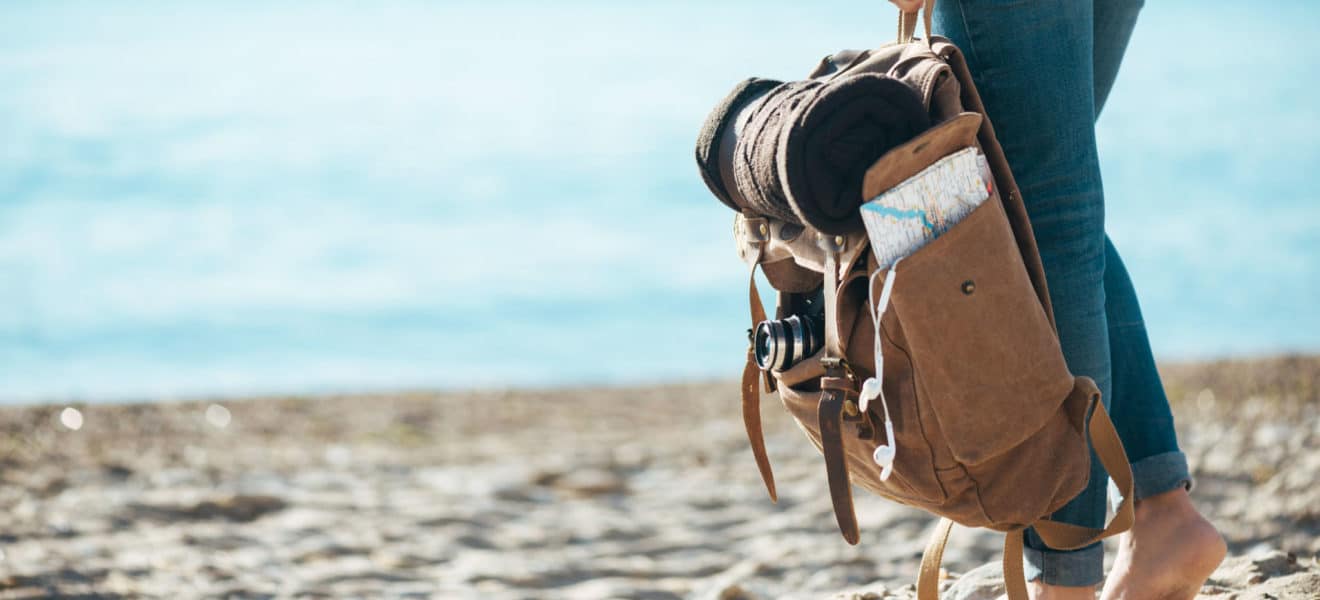 Dame på strand med bag med diabetesgadgets