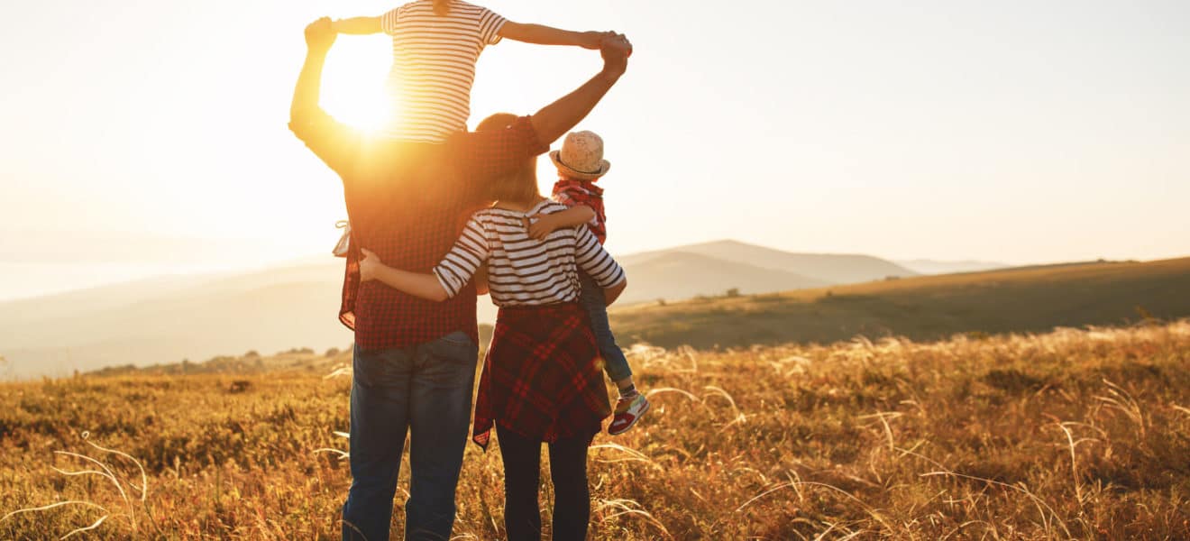 Familie på tur i solnoppgangen