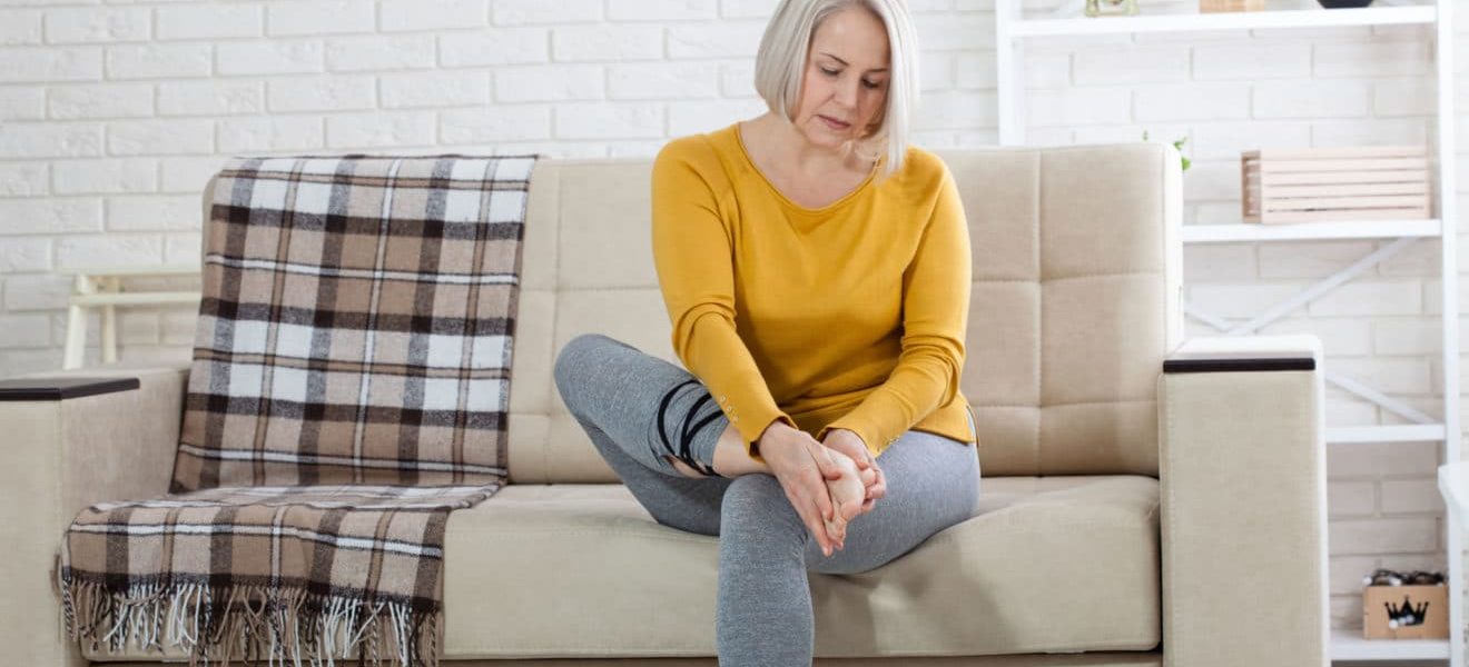 diabetes og plattfot, kvinne i sofaen med fotplager