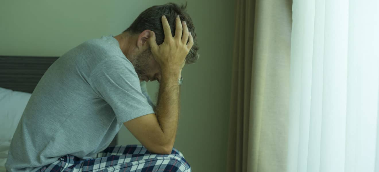 Trist og arbeidsløs mann som har møtt veggen i lockdown under korona pandemien
