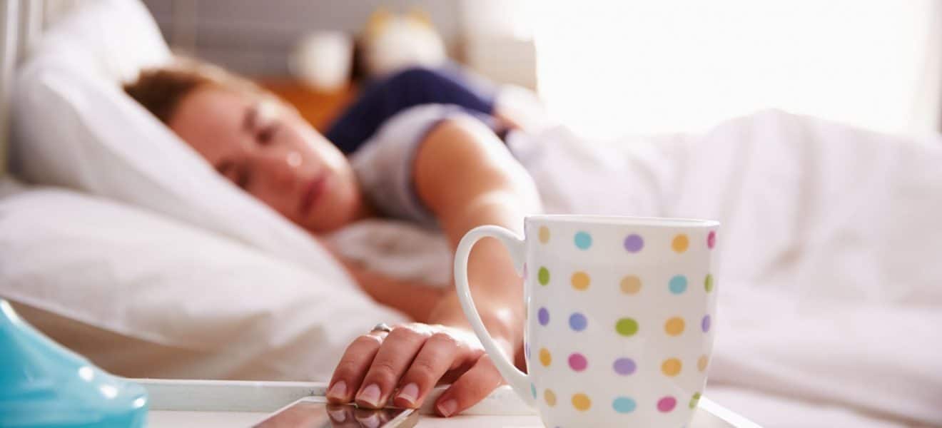 Kvinne våkner på morgenen og strekker seg etter telefonen. Slik ser min hverdag med diabetes ut.